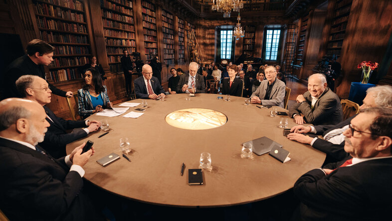 Nobel Prize laureates sitting around a round table 