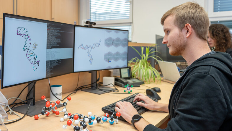 Researcher at his workspace with a model of a molecule on the desk