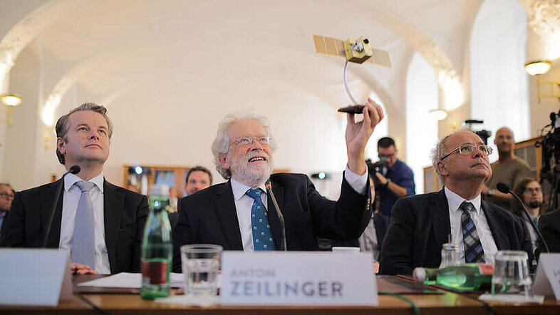 Anton Zeilinger (Bildmitte) mit einem Modell des Satelliten "Micius" in der Hand, rechts von ihm Rektor Heinz W. Engl