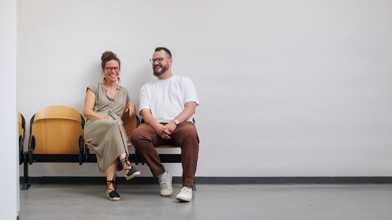 Janina Kehr und Robert Böhm scherzen miteinander im Korridor des neuen Institutsgebäudes, Halbtotale