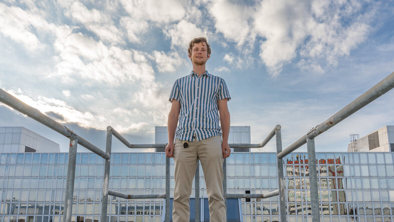 Blaž Gasparini auf einem Gebäude mit Wolken im Hintergrund