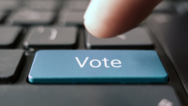 © Finger im Begriff, eine Taste mit Aufschrift VOTE auf einer Tastatur zu drücken