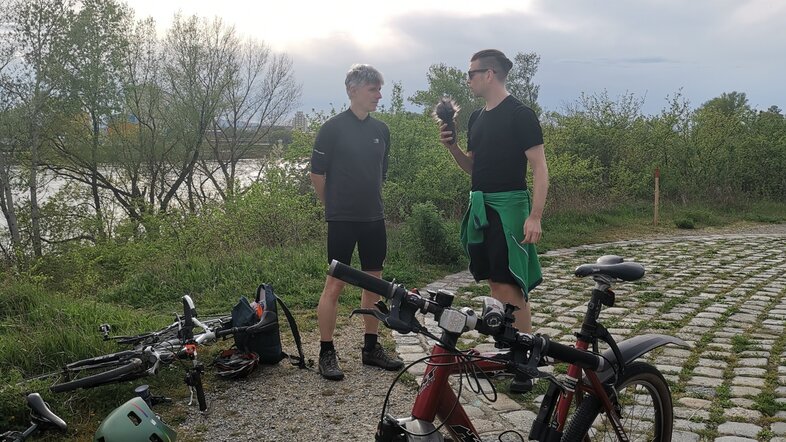 Michael Weissl und Mario Wasserfaller stehen hinter Fahrrädern beim Interview auf der Donauinsel