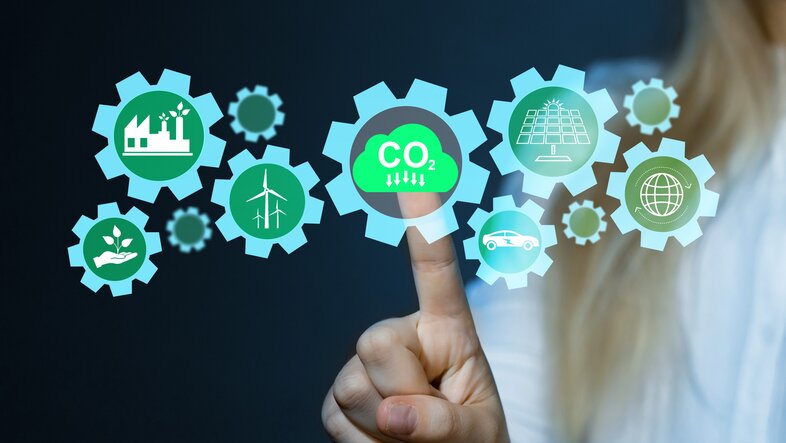 Grafik mit Icons, unter anderem CO2. Eine Person tippt auf das CO2 Icon und aktiviert es - CO2 muss sinken, um Klimaneutralität zu erreichen