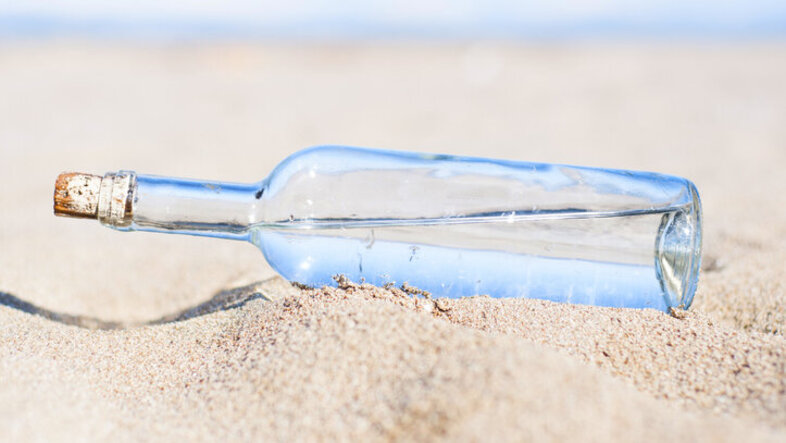 stock image showing a water bottle in the sand in the desert