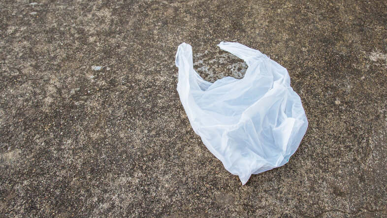 Plastic bag lies on an asphalt road