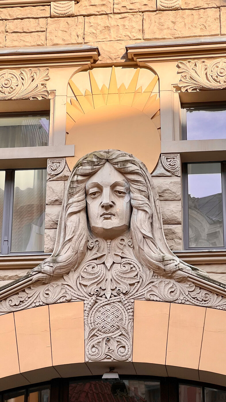 Detail of art nouveau facade showing a man's head carved from stone