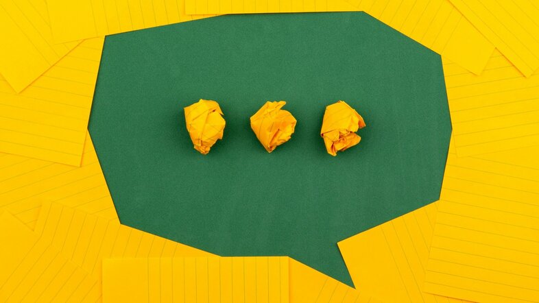 Green paper speech bubble with 3 yellow paper beads in the middle