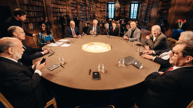 Nobel Prize laureates sitting around a round table 