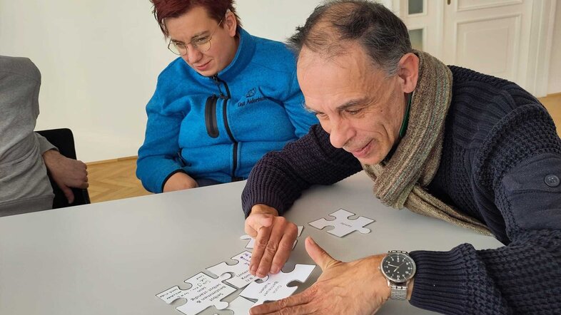 Man puts together jigsaw puzzle pieces