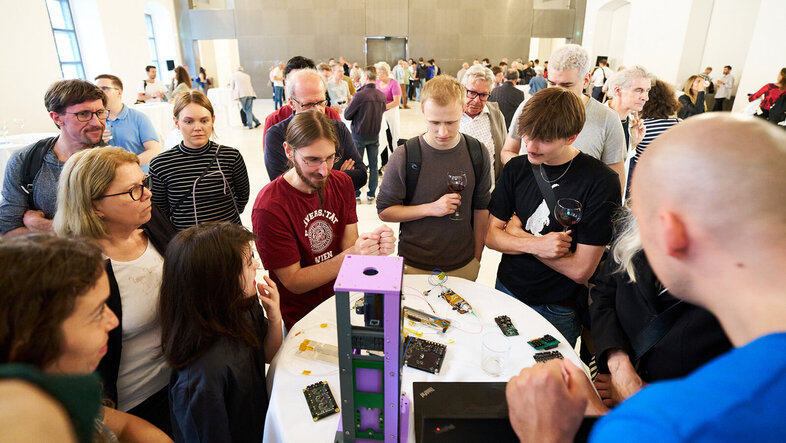 Umtrunk und Andrang beim Stand vom Quantencomputer