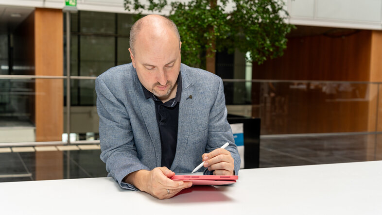 Laurenz Ennser-Jedenastik arbeitet mit einem iPad.