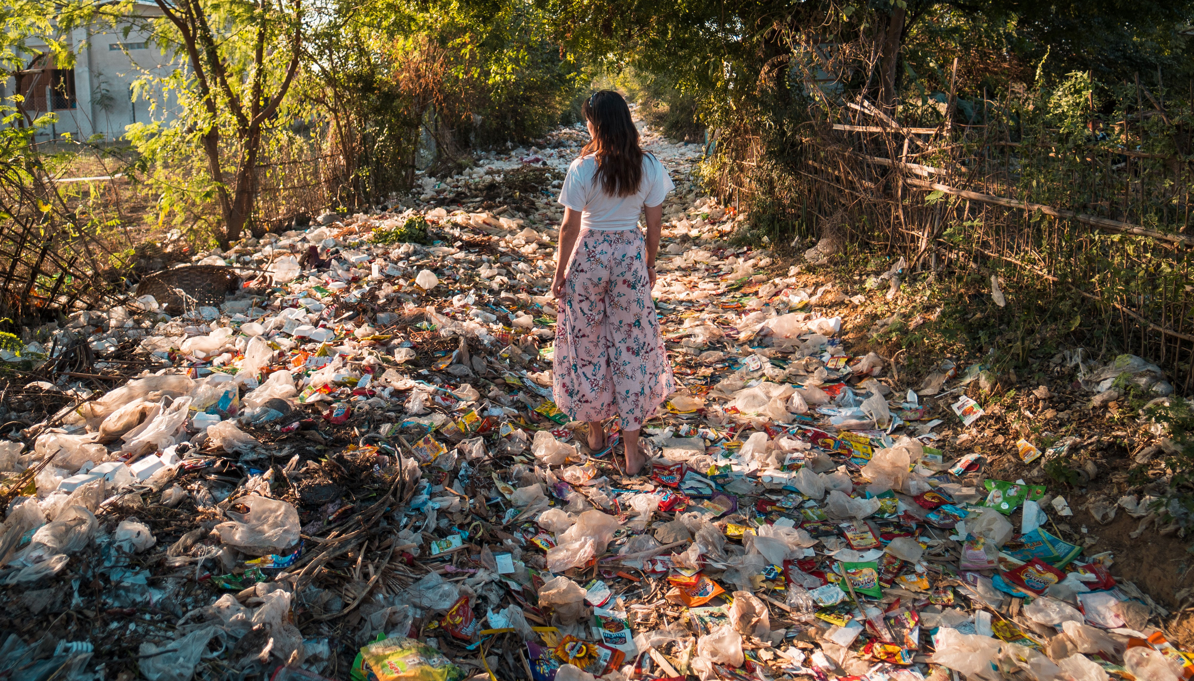 Frau umgeben von Plastikmüll