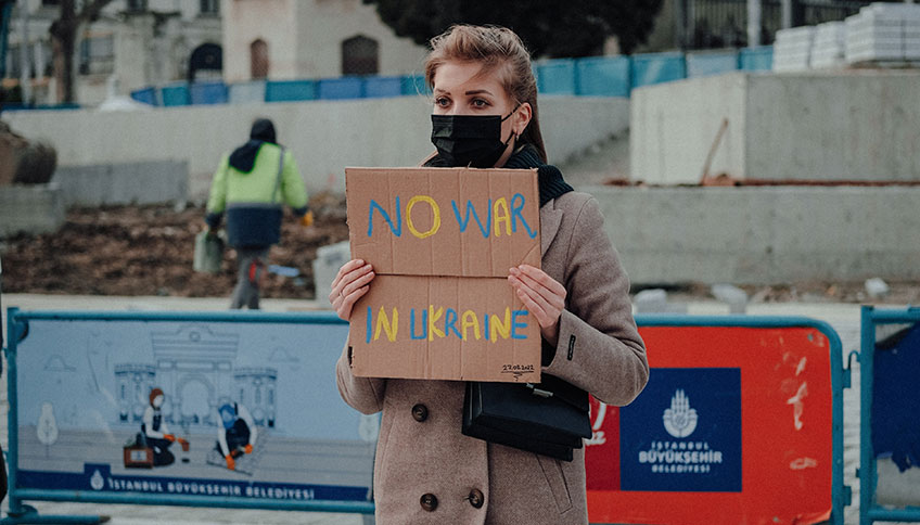 © Frau hält Schild mit der Aufschrift No War in Ukraine