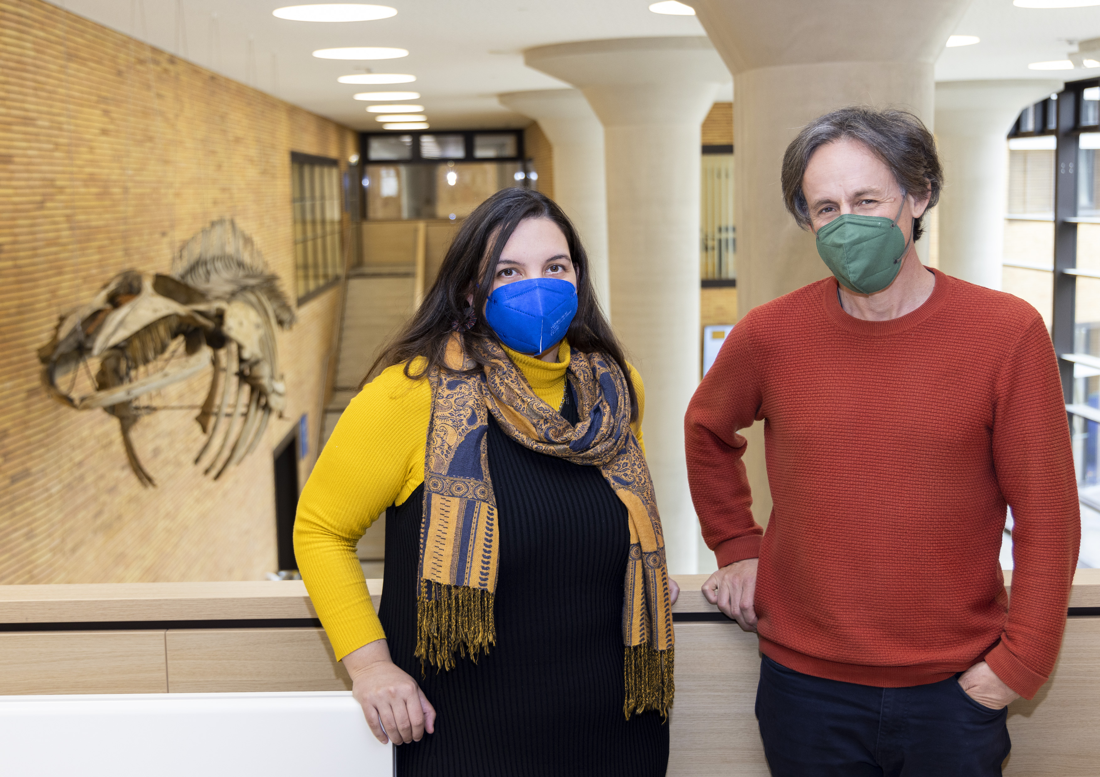 Katerina Douka and Tom higham Higham standing in the new Univie Biology Building. I the background there is a skeleton of a wale